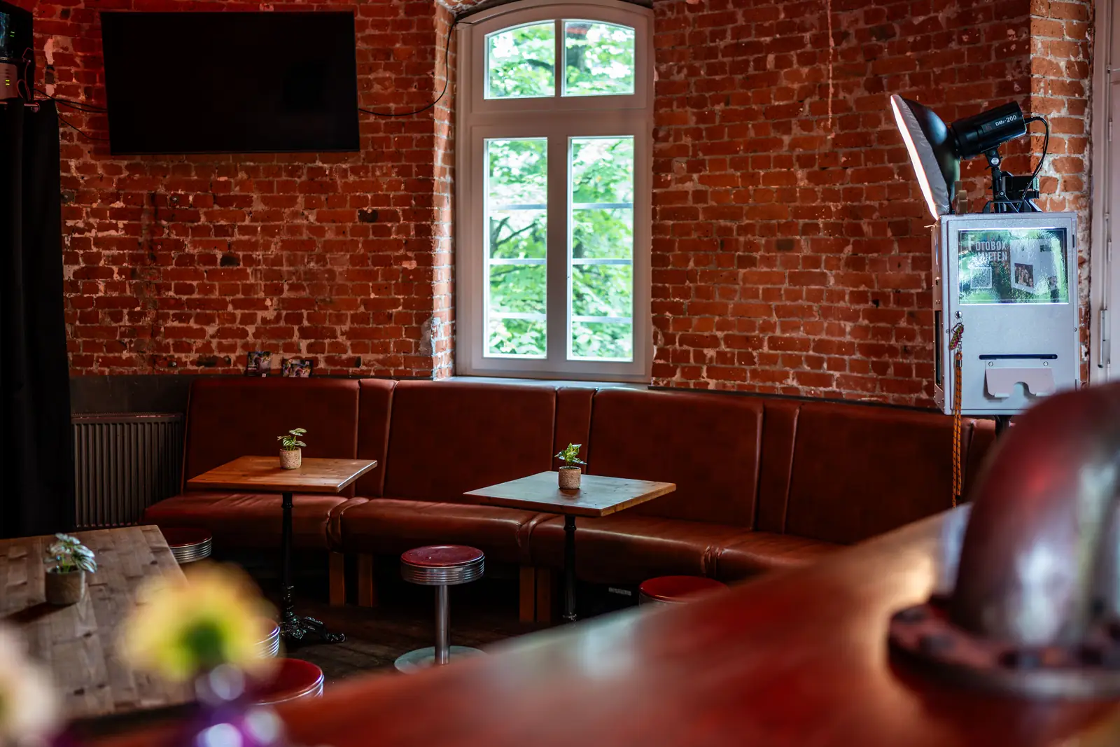 Sitzecke mit Ledersitzbank, Tischen und Fenstern im Backsteinraum, Sander Dickkopp in Hamburg-Lohbr&uuml;gge