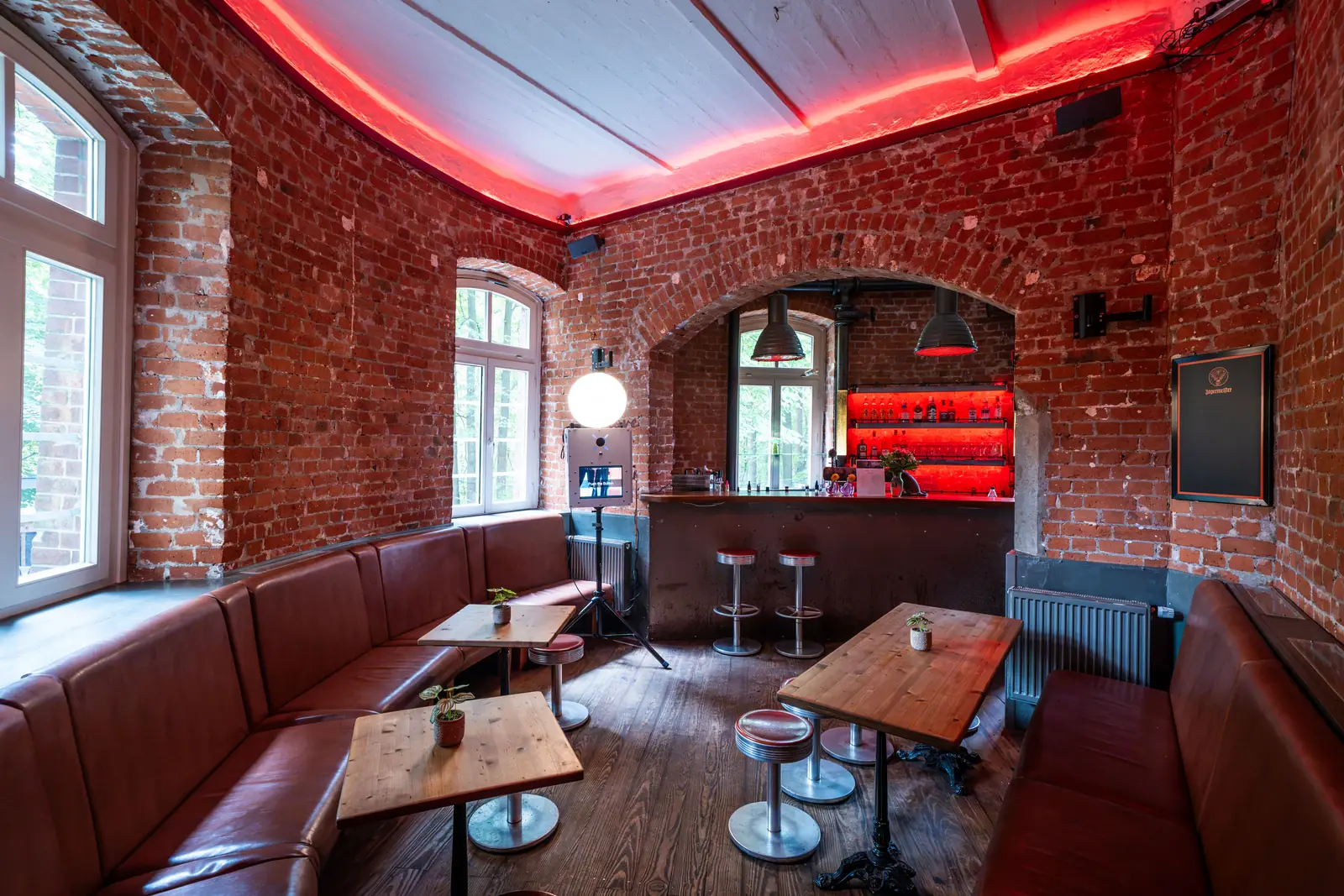 Barbereich mit Ledersitzbank, Holztischen und Backsteinwand, Sander Dickkopp in Hamburg-Lohbr&uuml;gge