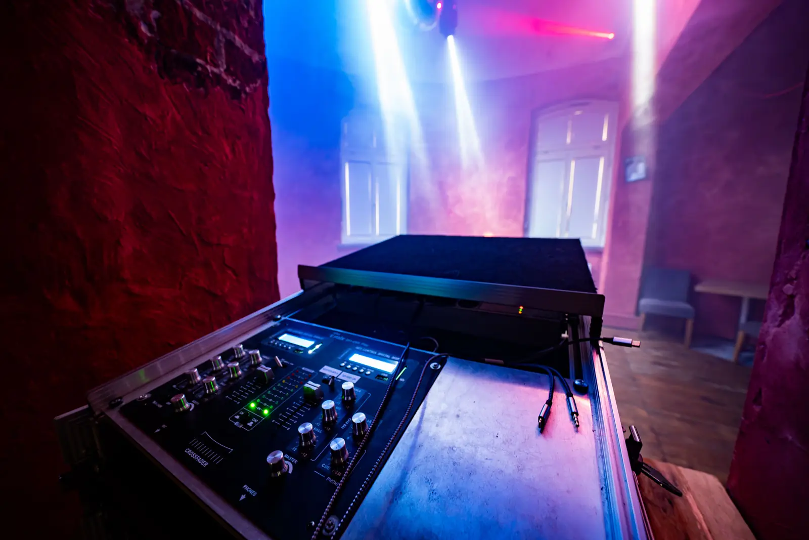DJ-Pult mit Mixer vor blau-violetter Lichtshow, Sander Dickkopp in Hamburg-Lohbr&uuml;gge