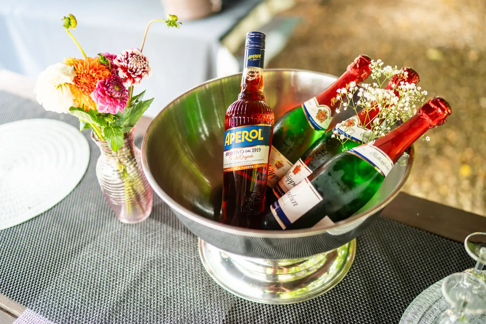 Sektk&uuml;hler mit Aperol und Sekt neben Blumen auf dem Tisch, Sander Dickkopp in Hamburg-Lohbr&uuml;gge