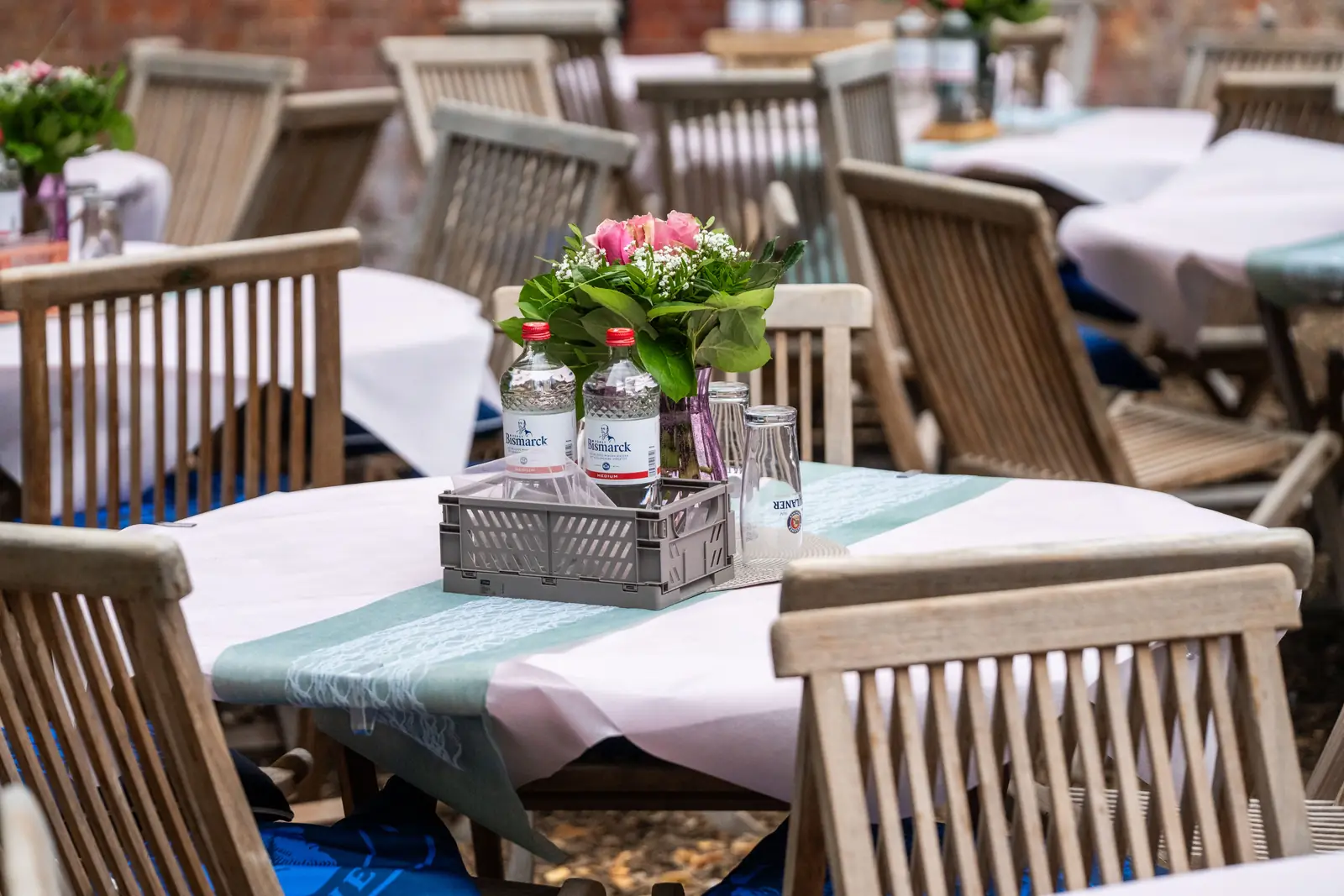 Gedeckter Gartentisch mit Blumen, Wasserflaschen und Tischl&auml;ufer, Sander Dickkopp in Hamburg-Lohbr&uuml;gge