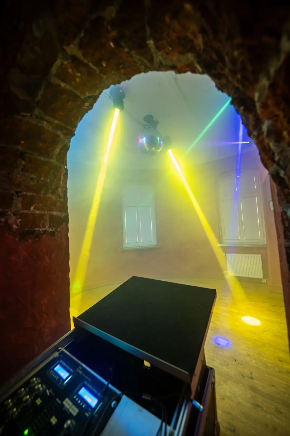 Torbogen mit Discokugel und gelben Lichtstrahlen &uuml;ber dem DJ-Pult, Sander Dickkopp in Hamburg-Lohbr&uuml;gge